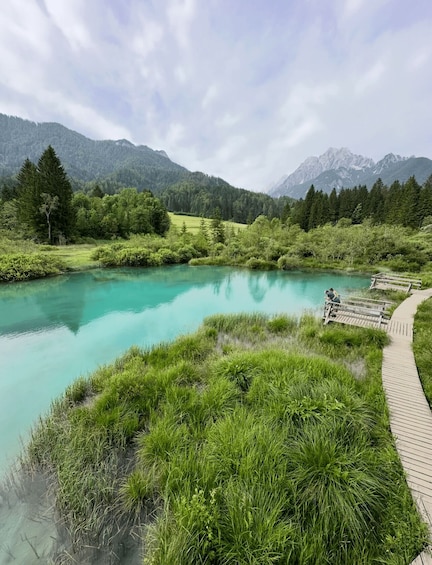 A turquoise lake surrounded by lush greenery and mountains. 4