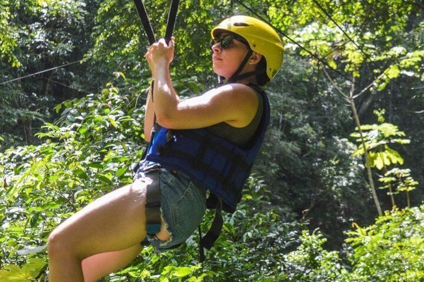 Una persona deslizándose en tirolesa por un bosque. 4