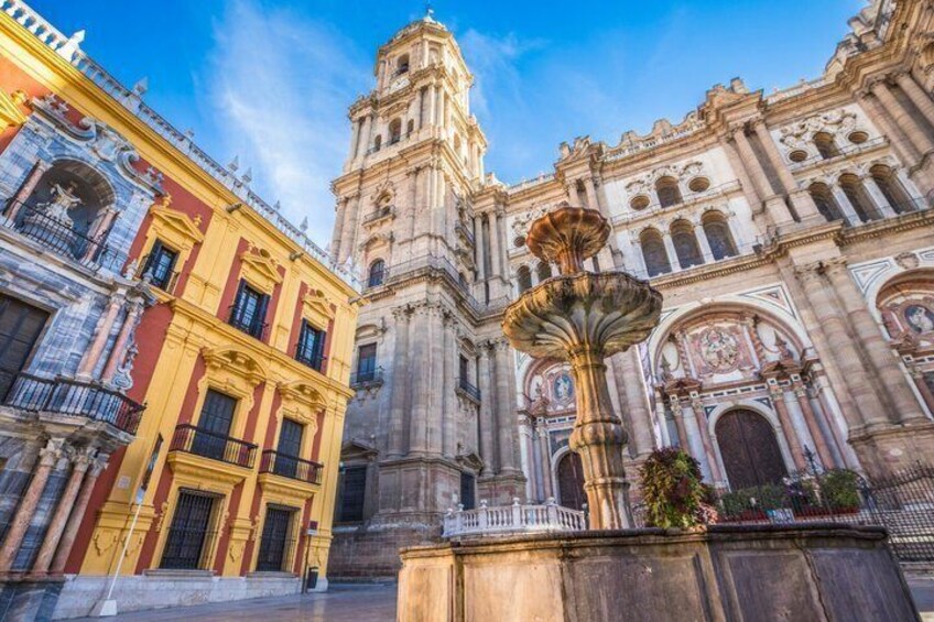 Un edificio histórico con una destacada torre de campanas y una fuente en primer plano. 5