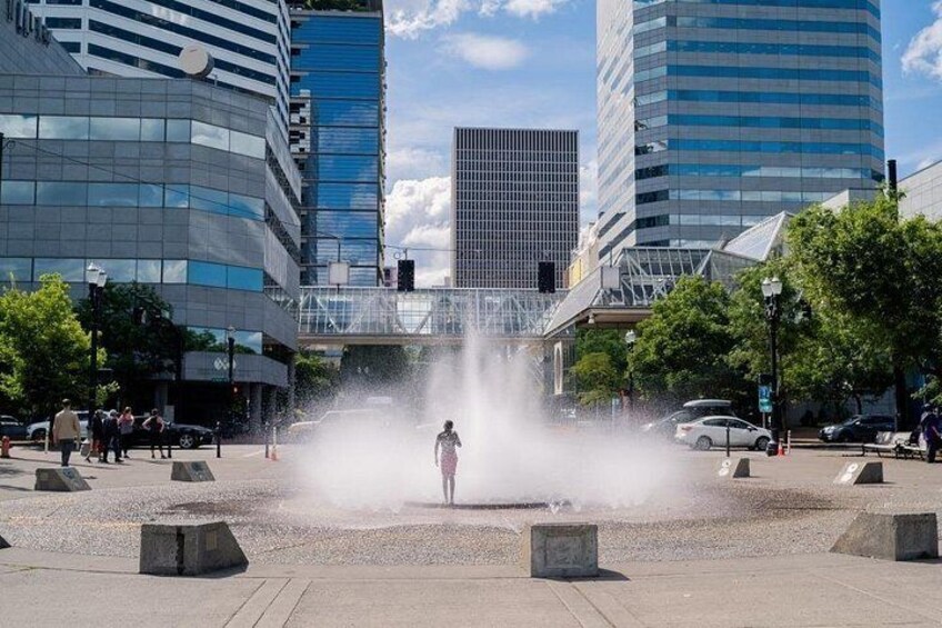 A fountain in an urban plaza with modern buildings in the background. 5