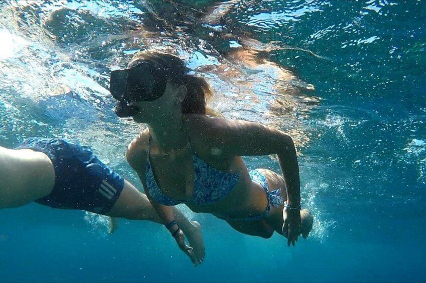Une personne nageant sous l’eau avec un tuba et un masque. 2