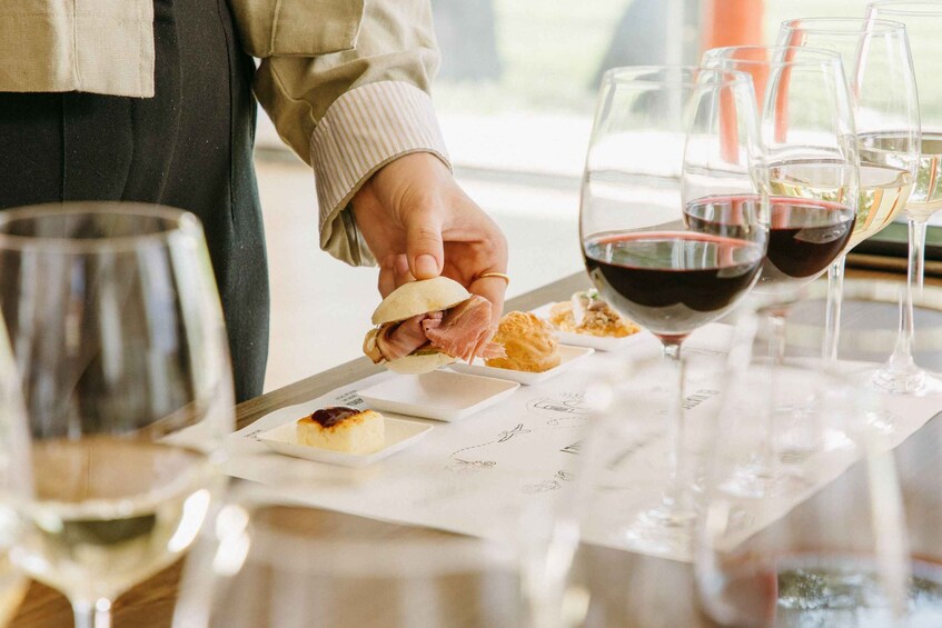 A person serving food on a tray with wine glasses on a table. 3