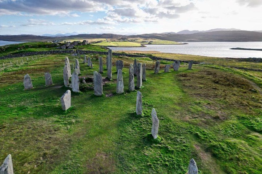 A stone circle with a lake and hills in the background. 2