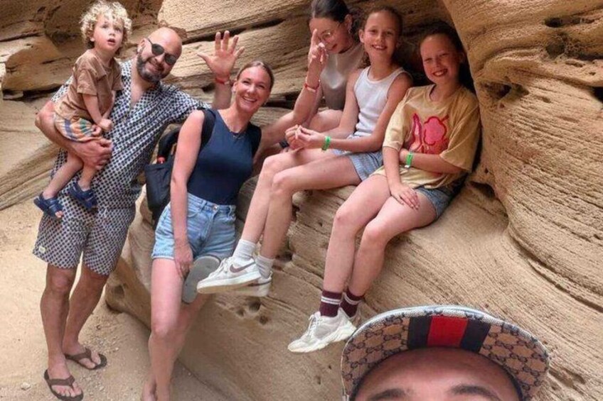 A group of people sitting on a rock formation. 4