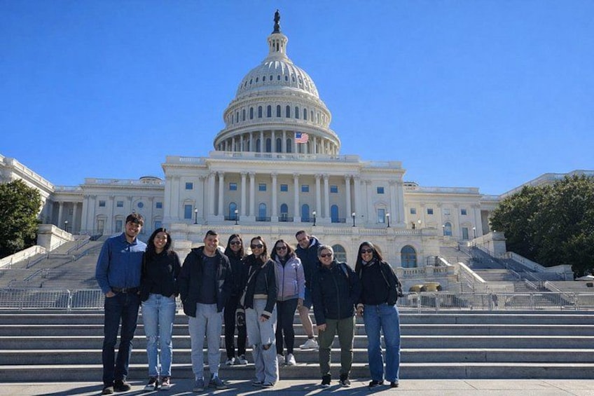 A group of people standing in front of the United States Capitol building. 2