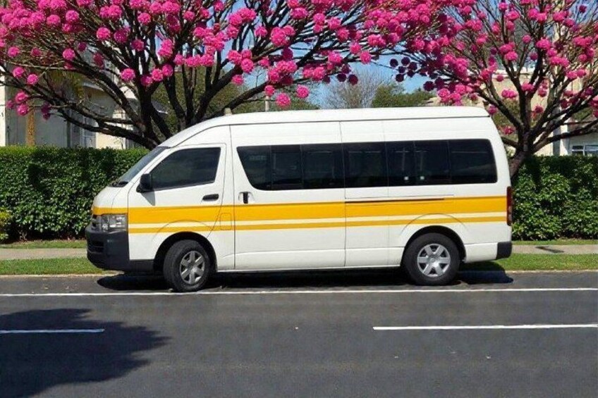 Una camioneta blanca con franjas amarillas estacionada en una calle. 4