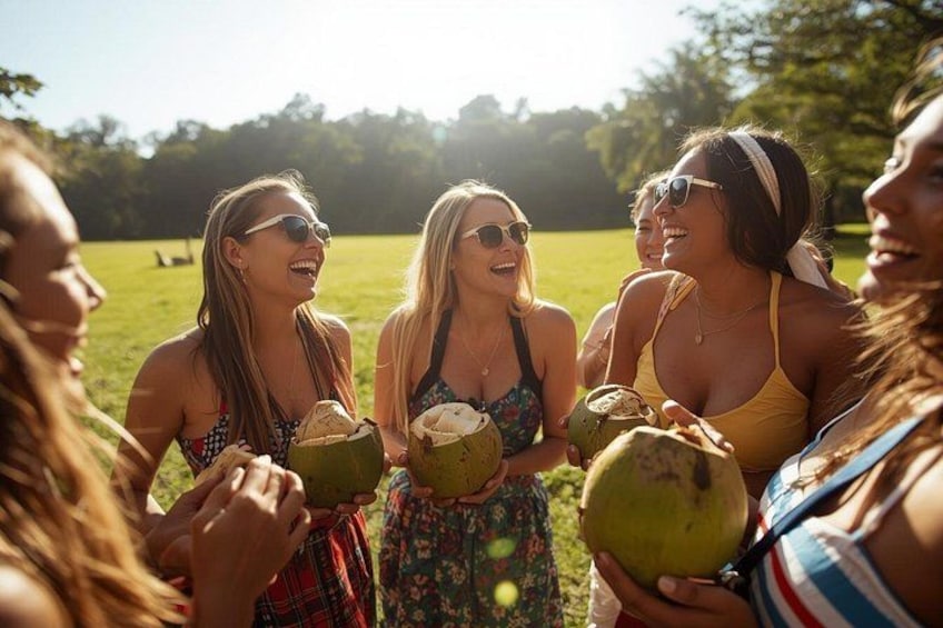 A group of people outdoors holding coconuts. 1