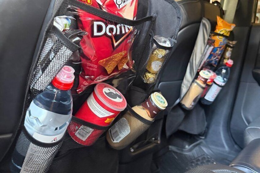 La console centrale d’une voiture est équipée d’un compartiment de rangement contenant des collations, des boissons et une bouteille d’eau. 2