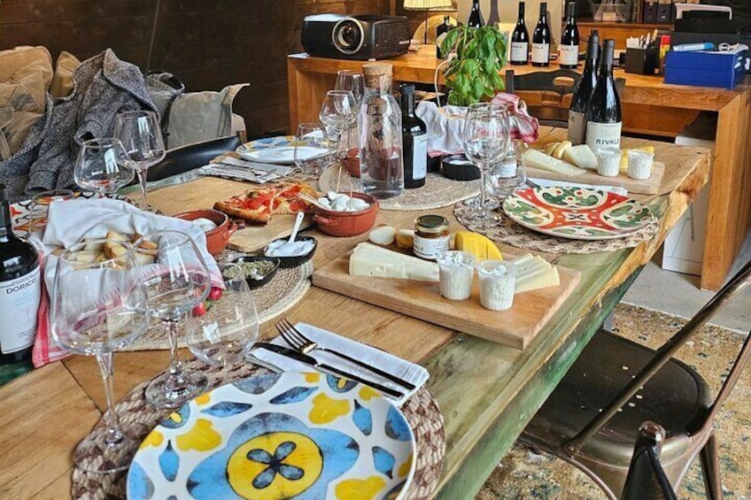 Una mesa servida para una comida, con copas de vino, platos y botellas. 5