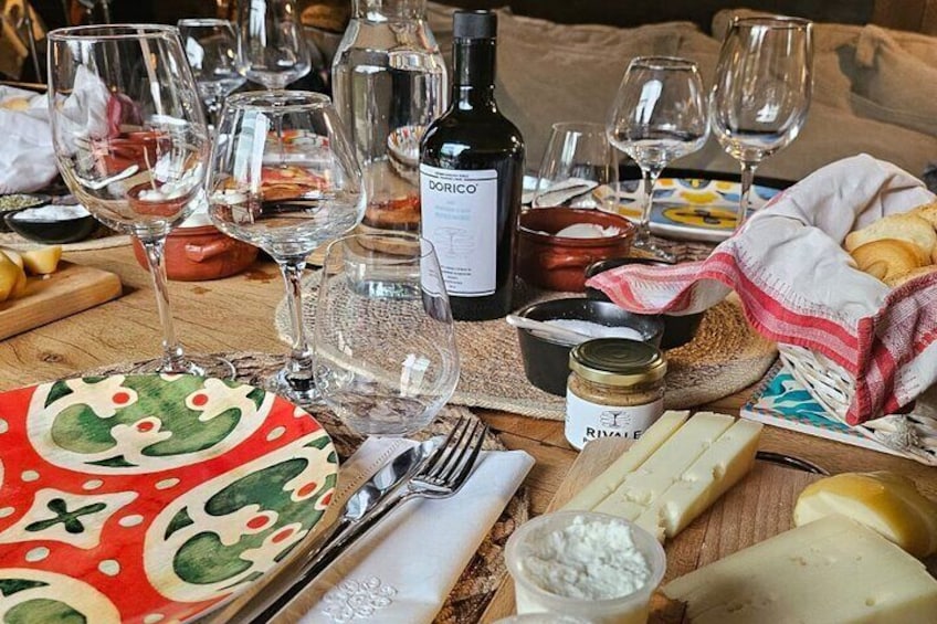 Una mesa con copas de vino, una botella, queso y pan. 2