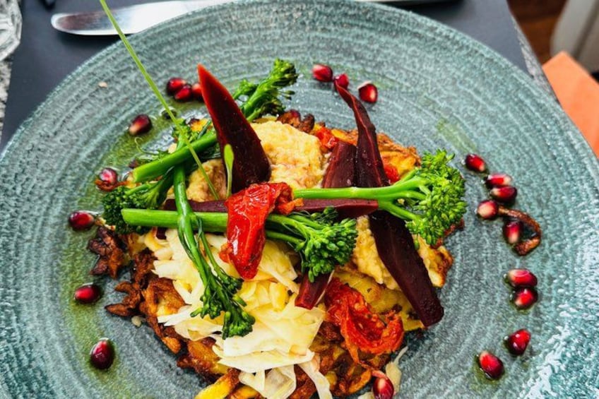 Un plato de comida con vegetales y semillas de granada. 2