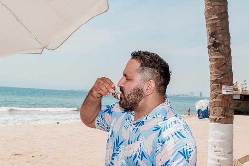 A person on a beach with a palm tree and a beach umbrella. 5