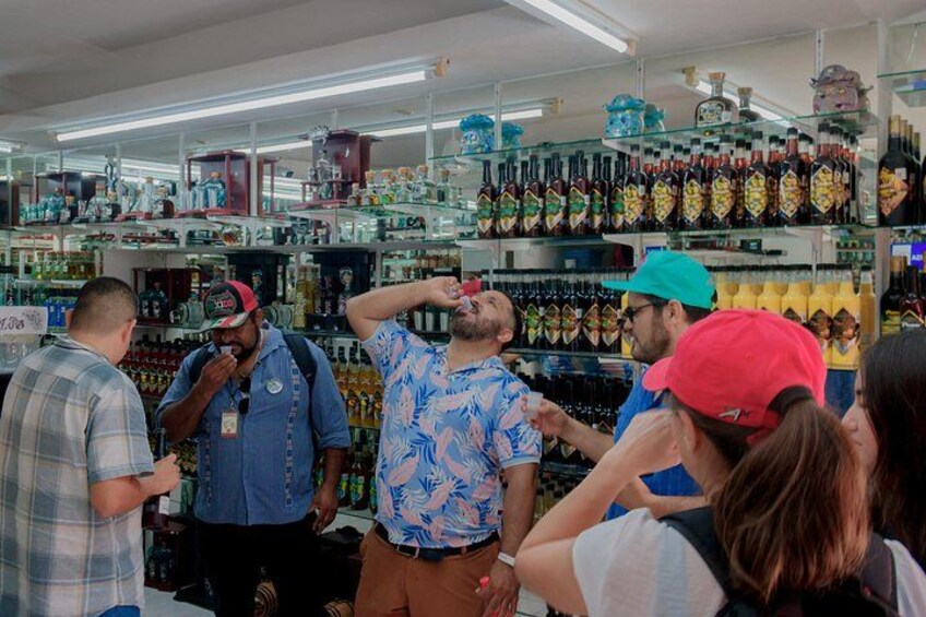 A store interior with shelves stocked with various bottles and a group of people browsing. 3