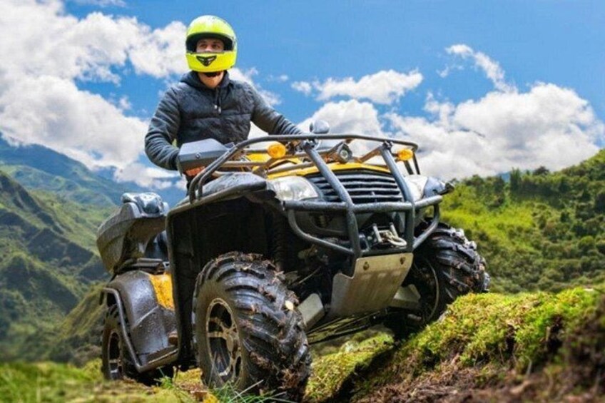 Una persona en un vehículo de cuatro ruedas en una zona montañosa con vegetación y cielo despejado. 5