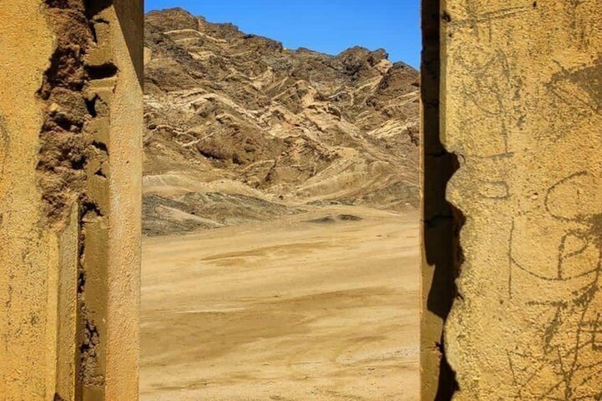 A desert landscape with rocky mountains in the background and a clear sky. 4