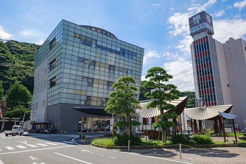 A modern building with a glass facade, a traditional Japanese-style structure, and a tall building with a clock tower. 3