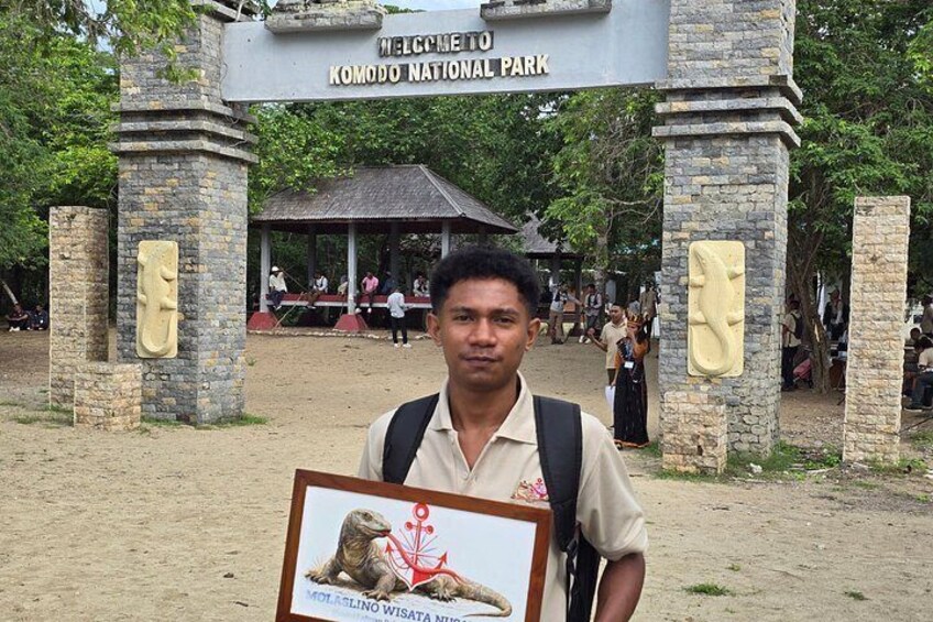 A man holding a framed picture at Komodo National Park entrance. 4