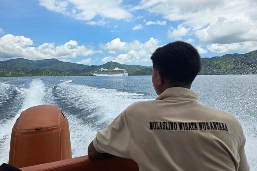 A person on a boat with a ship in the background. 3