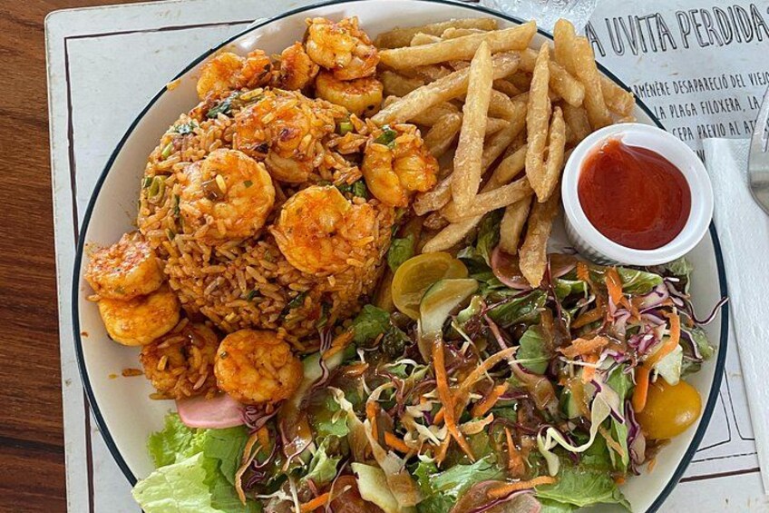 A plate of shrimp fried rice, French fries, a salad, and a small bowl of ketchup. 2