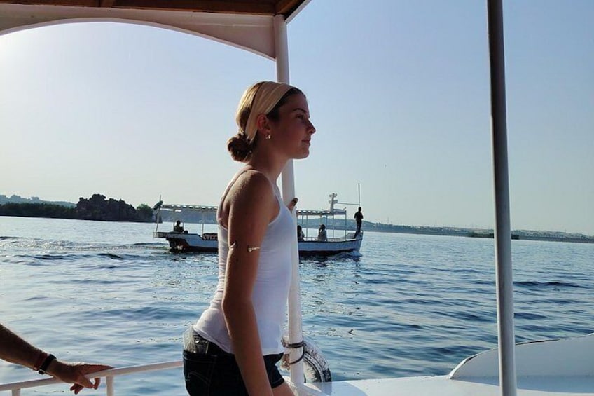 A person on a boat with a view of the water and another boat in the distance. 2