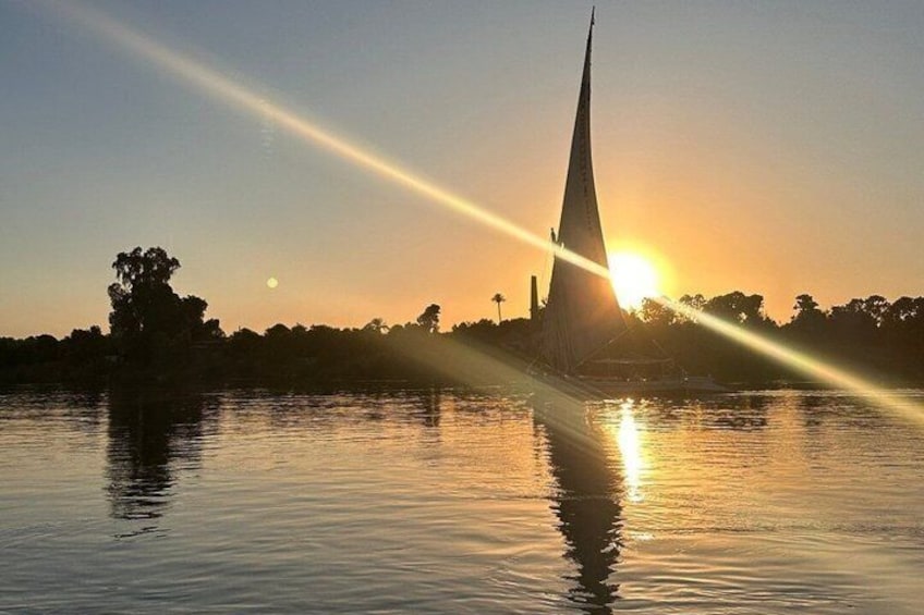 Un atardecer sobre una masa de agua con una estructura en forma de aguja que refleja los rayos del sol. 1