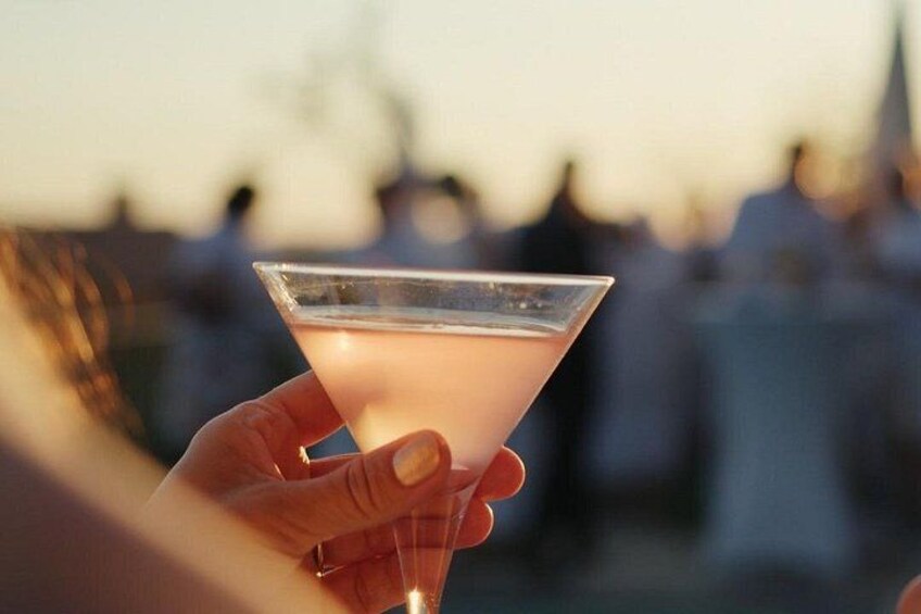 Une main tenant un verre à martini contenant une boisson rosée. 5