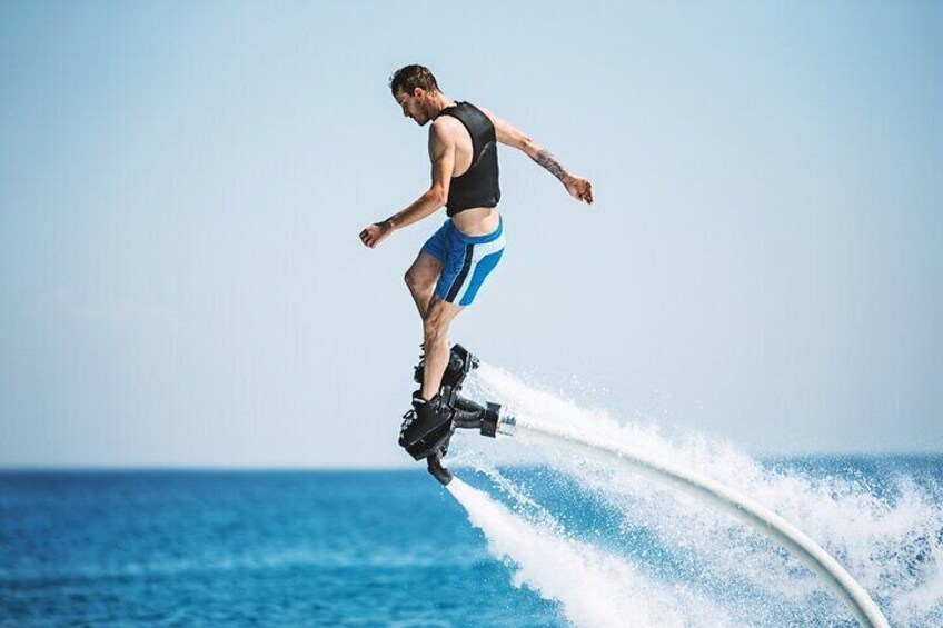 A person performing a high jump on a jet ski over water. 3