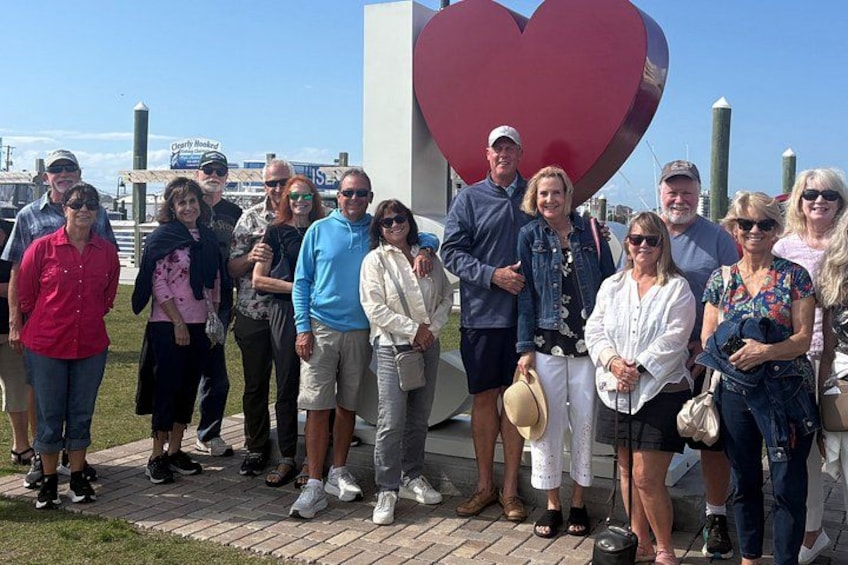 A group of people standing in front of a large heart-shaped structure. 2