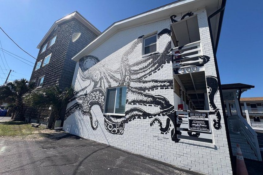 A building with a large octopus mural on the side. 3