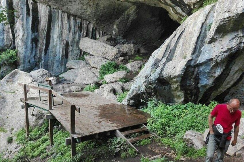 A rocky outdoor area with a wooden platform and a person standing on it. 3