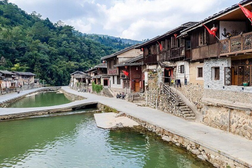 Traditional wooden houses, a stone bridge, and a small pond in a mountainous area. 5