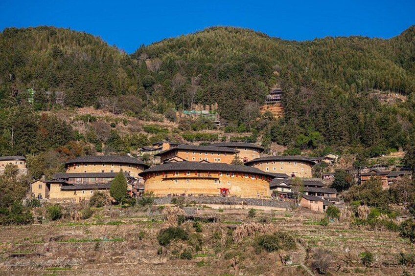 A traditional building complex surrounded by forested hills. 4