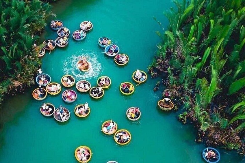 A group of people in small boats on a turquoise body of water surrounded by lush greenery. 4