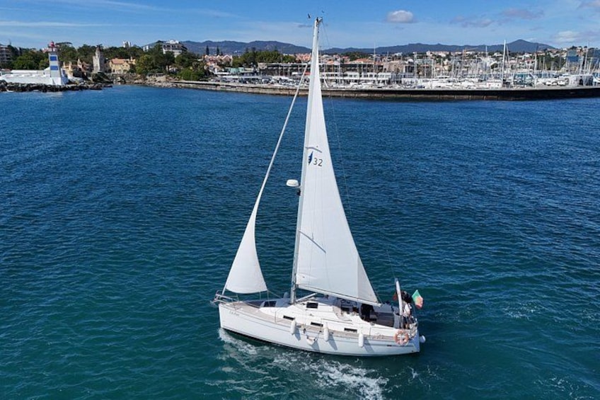 A sailboat with two sails on a calm body of water. 1