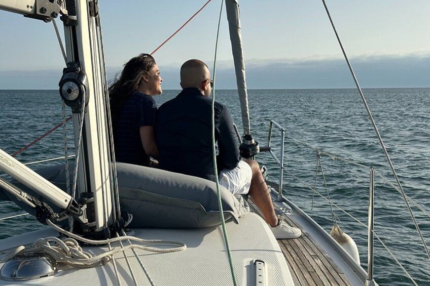 A couple on a sailboat with the ocean in the background. 4