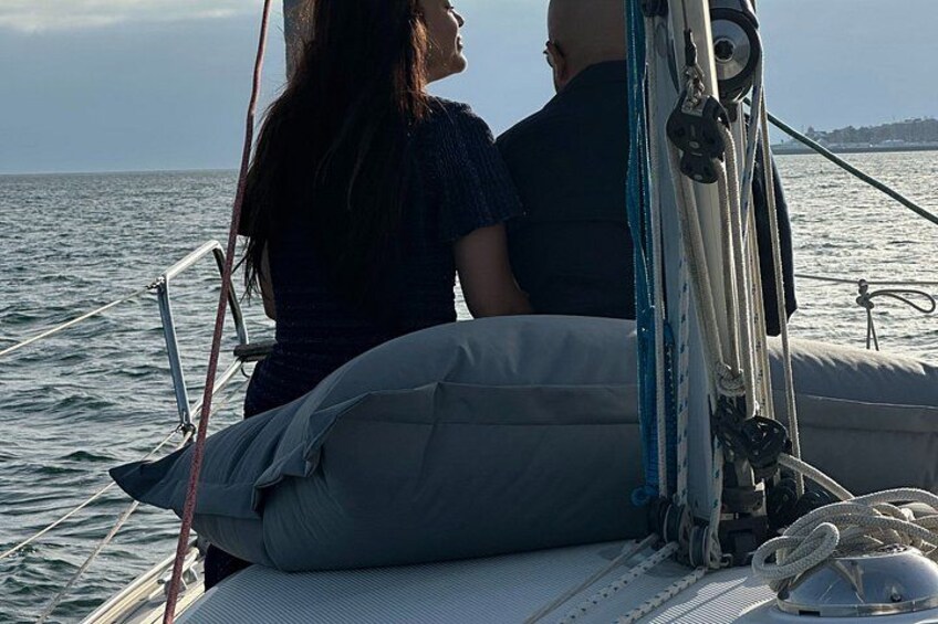 A couple on a sailboat with a view of the sea and distant land. 5