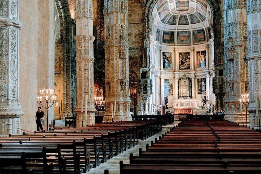 Interior de una iglesia ornamentada con techos altos, columnas detalladas y un altar central. 3