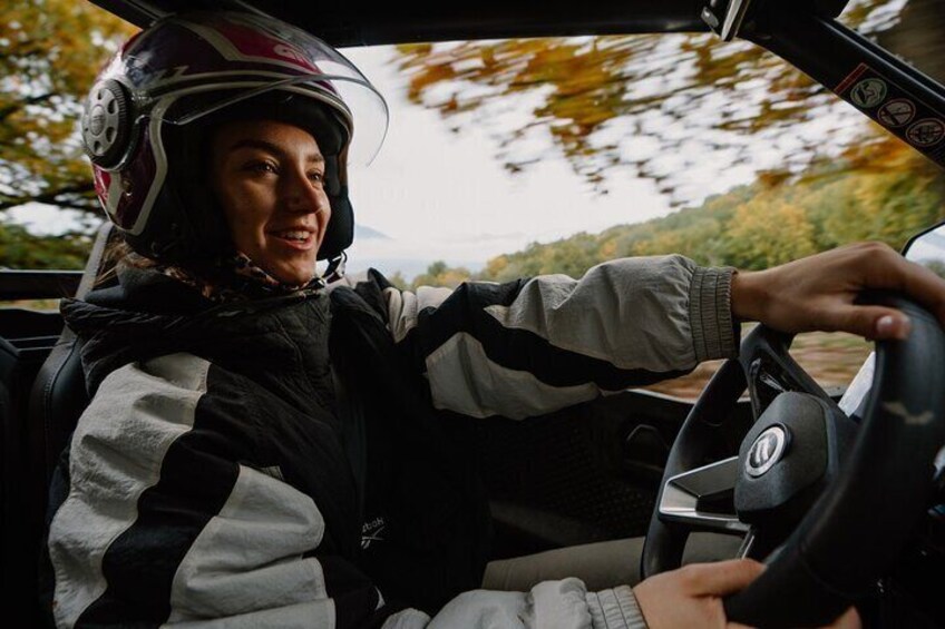 A person driving a car with a steering wheel and dashboard. 5
