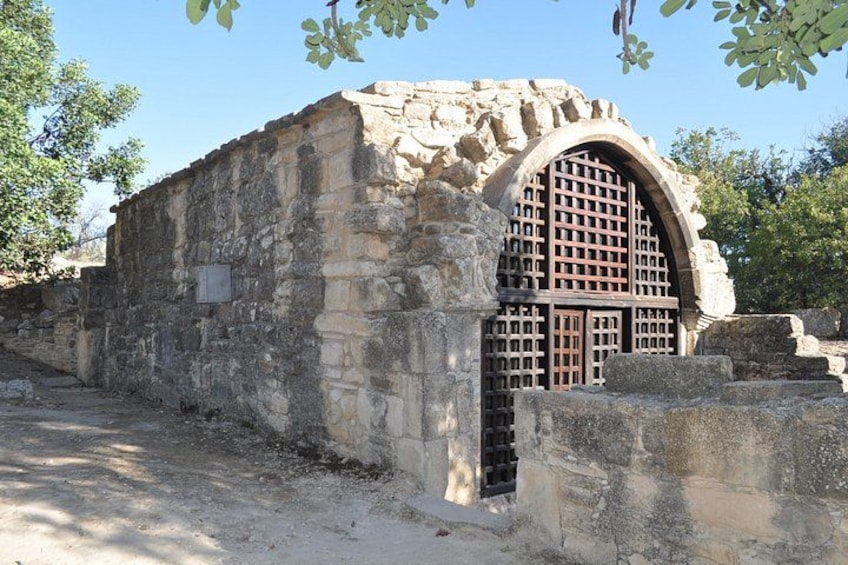 An ancient stone building with a large arched doorway and a grid-like window. 2