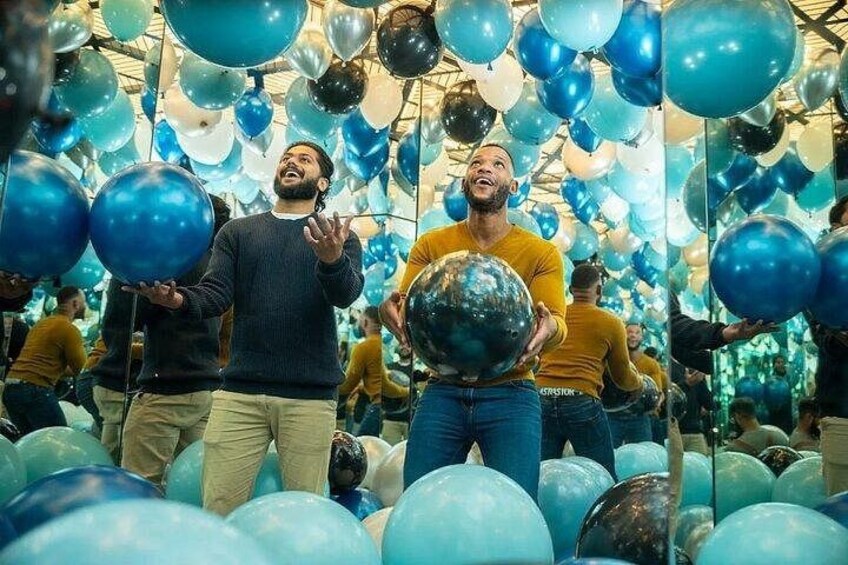 A room filled with blue and black balloons. 1