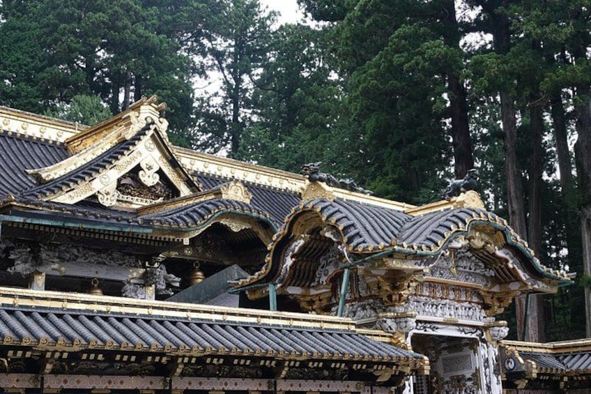 Traditional Japanese architecture with ornate roofs and a waterfall. 2
