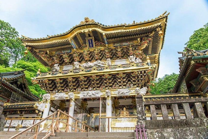 A traditional Japanese temple with ornate golden architecture and a multi-tiered roof. 1