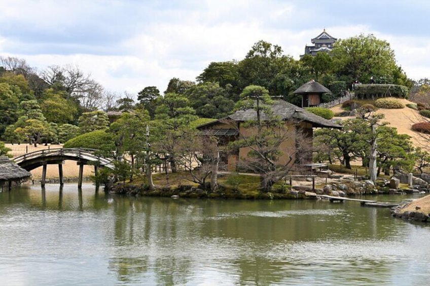 A traditional Japanese garden with a pond, a stone bridge, and a pagoda. 1