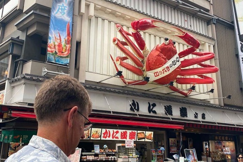 Un ristorante con una grande decorazione a forma di granchio e insegne in caratteri giapponesi. 5