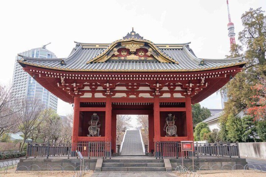 Un torii japonés tradicional con pilares rojos y un tejado dorado, que da paso a un sendero. 4