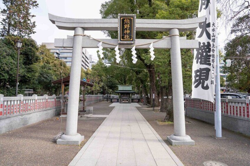Un torii japonés tradicional con un cartel en primer plano. 2