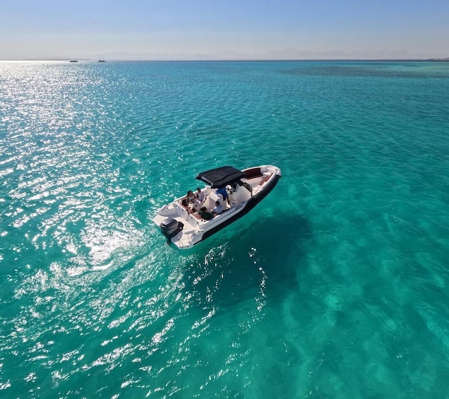 Un bateau à moteur filant sur une eau turquoise, sous un ciel dégagé. 1