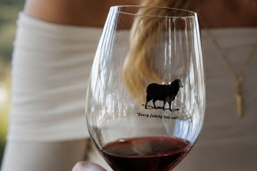 A wine glass with a silhouette of a sheep and the text 'Every family has one.' 5