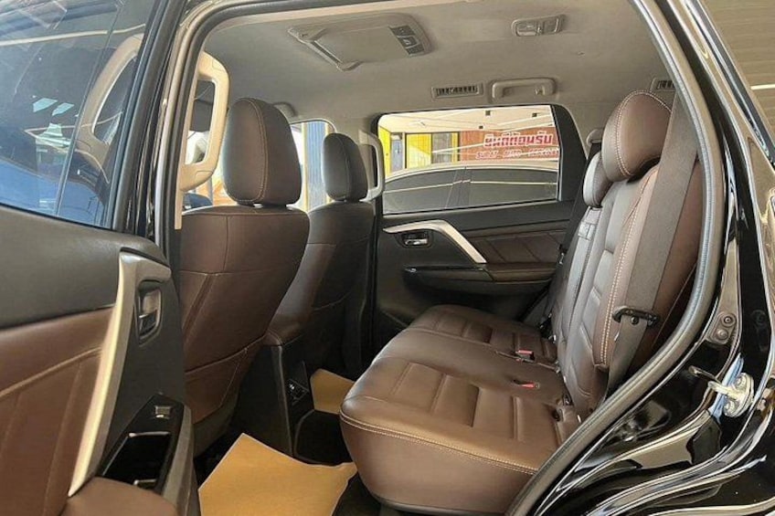 Ein Auto Innenraum mit braunen Ledersitzen, einem Schiebedach und einem Rückspiegel. 5