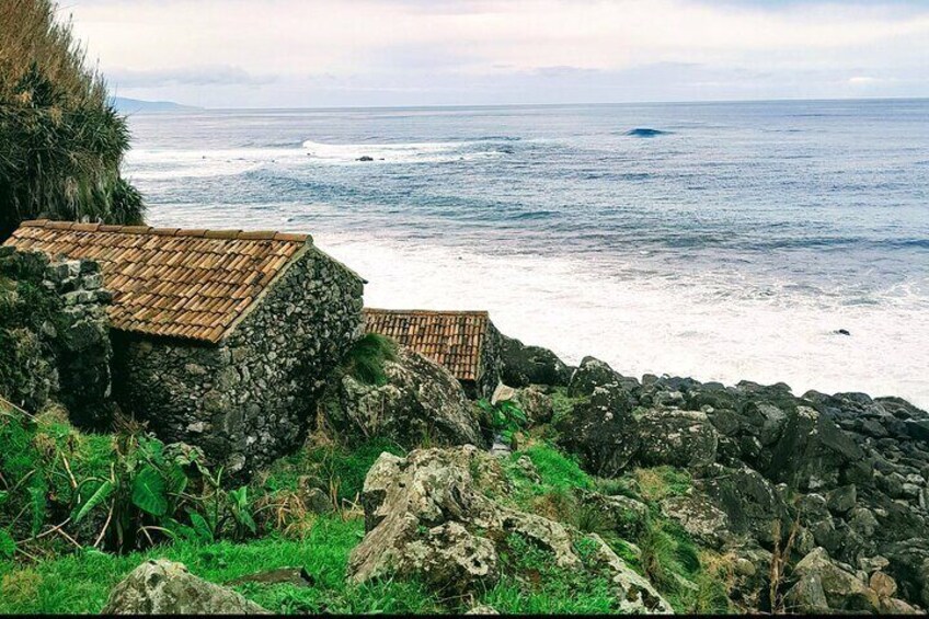 Paisaje costero con un edificio de piedra y terreno rocoso. 2